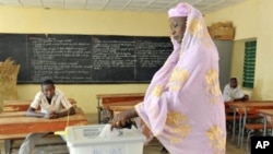 A woman casts her vote for Niger's presidential election at a polling station in Niamey, March 12, 2011