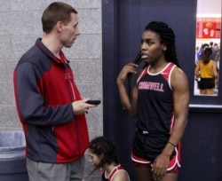 FILE — In this Feb. 7, 2019 file photo, Cromwell High School track coach Brian Calhoun, left, speaks to transgender athlete Andraya Yearwood during a break at a meet at Hillhouse High School in New Haven, Conn. (AP Photo/Pat Eaton-Robb, File)