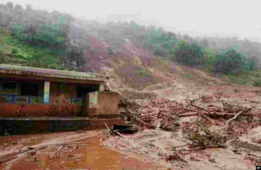 Mud surrounds a building after a mudslide in Malin village, in the western Indian state of Maharashtra, Wednesday, July 30, 2014