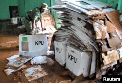 An officer looks for ballot boxes which can still be used, at a warehouse hit by flood and mudslides, in Bogor, West Java province, Indonesia, April 15, 2019 in this photo taken by Antara Foto. Antara Foto/Arif Firmansyah/