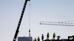 FILE - Construction workers unload supplies off a hoisted pallet on a rooftop in Atlanta, June 7, 2016. Workers' productivity increased in the third quarter at a 3.1 percent rate, the Labor Department reported Dec. 6, 2016.