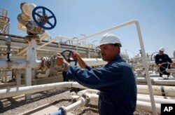 FILE - Employees work at the Tawke oil field in the semiautonomous Kurdish region in northern Iraq, May 31, 2009.