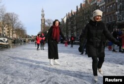 People ice skate during a cold snap across the country at the Prinsengracht in Amsterdam, Netherlands February 14, 2021. (REUTERS/Eva Plevier)