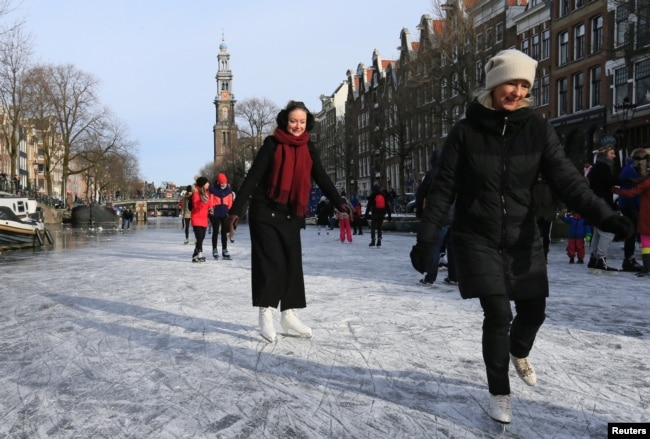 People ice skate during a cold snap across the ｃountry at the Prinsengracht in Amsterdam, Netherlands February 14, 2021. (REUTERS/Eva Plevier)