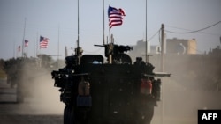 FILE - A convoy of U.S. forces drives near the village of Yalanli, on the western outskirts of the northern Syrian city of Manbij, March 5, 2017. 