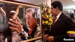 El presidente a cargo Nicolás Maduro observa una fotografía de Hugo Chávez, durante sus funerales.