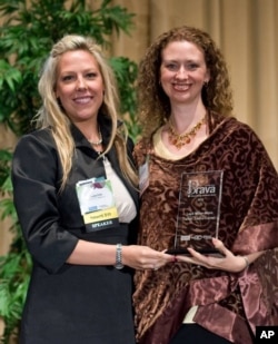 Layli Miller-Muro, (right), executive director of the Tahirih Justice Center, receives a 2010 BRAVA! Women Business Achievement Award.