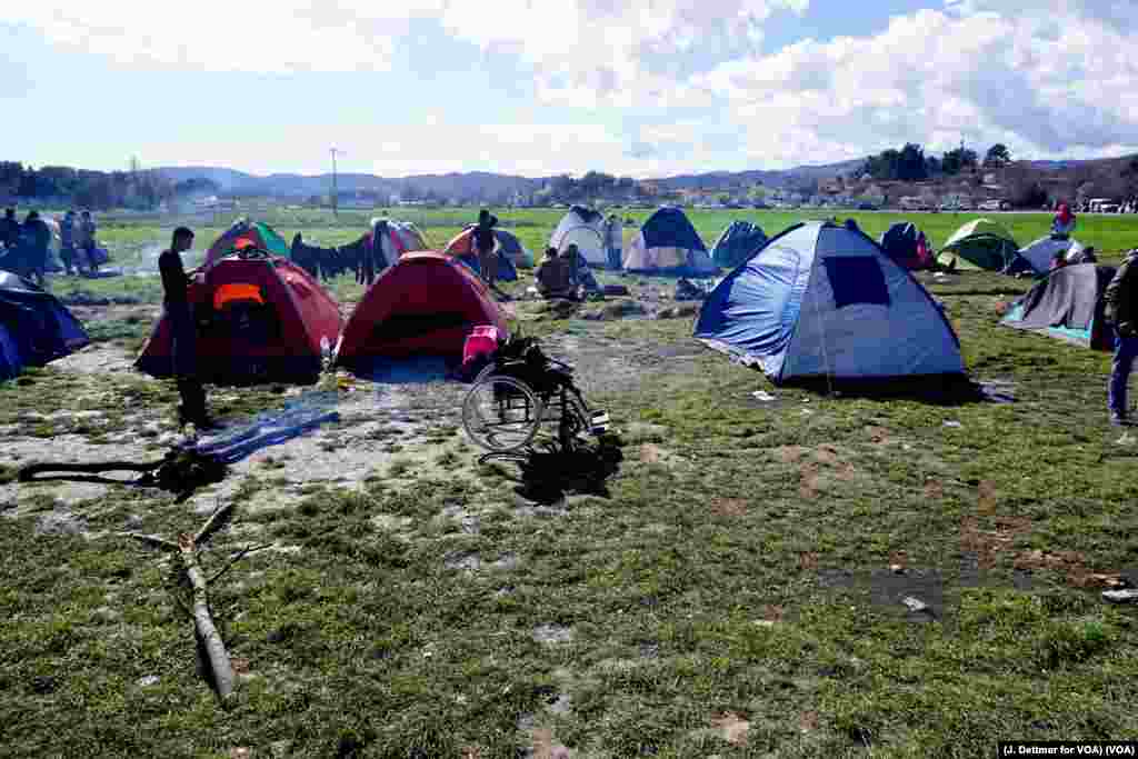 An empty wheelchair sits amid tents scattered outside the northern Greek border town of Idomeni, March 4, 2016. (J. Dettmer for VOA) 