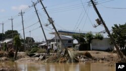 Electric poles tilt damaged after floods hit Joso, Ibaraki prefecture, northeast of Tokyo, Friday, Sept. 11, 2015.