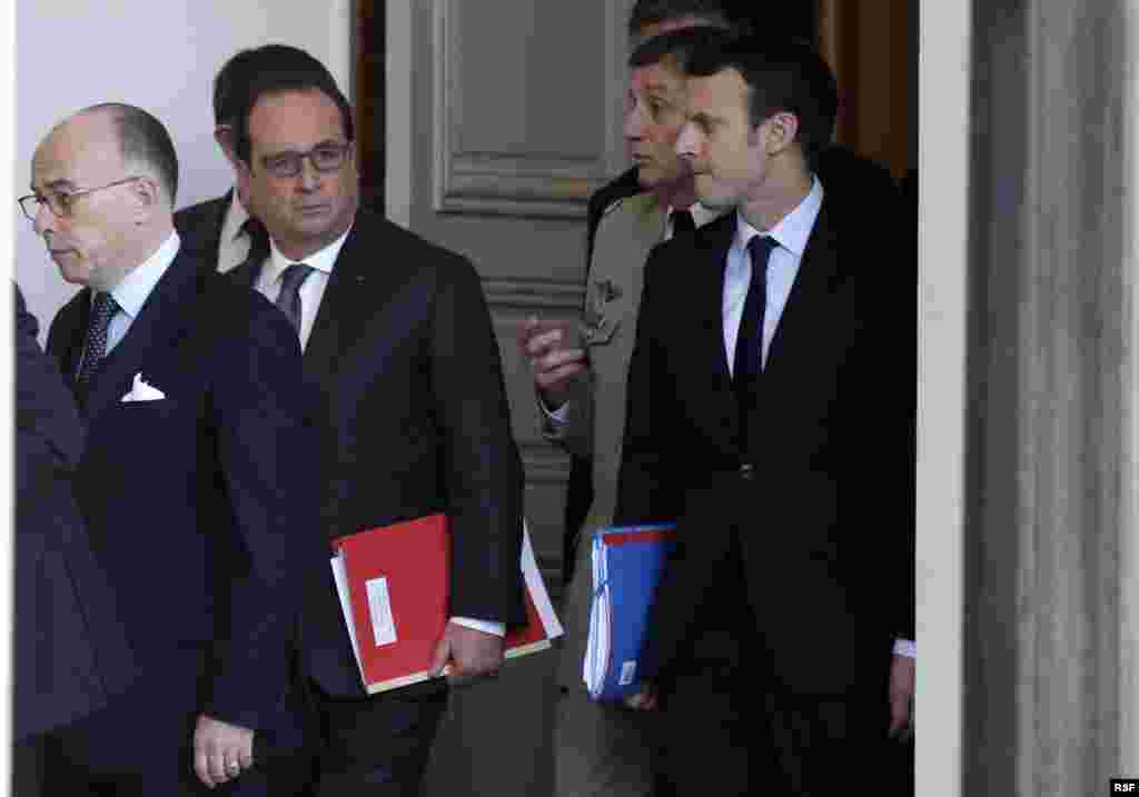 From left, French Interior Minister Bernard Cazeneuve and President Francois Hollande and other officials walk out of the Elysee Palace after a Defense council meeting following attacks Friday in Paris, France, Nov. 14, 2015.