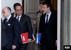 From left, French Interior Minister Bernard Cazeneuve and President Francois Hollande and other officials walk out of the Elysee Palace after a Defense council meeting following attacks Friday in Paris, France, Nov. 14, 2015.