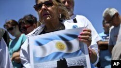 En esta imagen de archivo, tomada el 25 de noviembre de 2017, una mujer sostiene un cartel con el mensaje "Valientes del ARA San Juan, estamos con ustedes", delante de la base naval de la Armada en Mar del Plata, Argentina, (AP Foto/Esteban Félix, archivo)