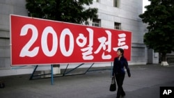 ແມ່ຍິງເກົາຫຼີເໜືອ ຄົນໜຶ່ງ ຍ່າງຜ່ານປ້າຍທີ່ມີຂໍ້ຄວາມວ່າ "200 ມື້ ຂອງການປຸກລະດົມ" ຢູ່ໃນນະຄອນຫຼວງ Pyongyang, ຂອງເກົາຫຼີເໜືອ ເມື່ອວັນເສົາ ທີ 25 ມິຖຸນາ 2016.