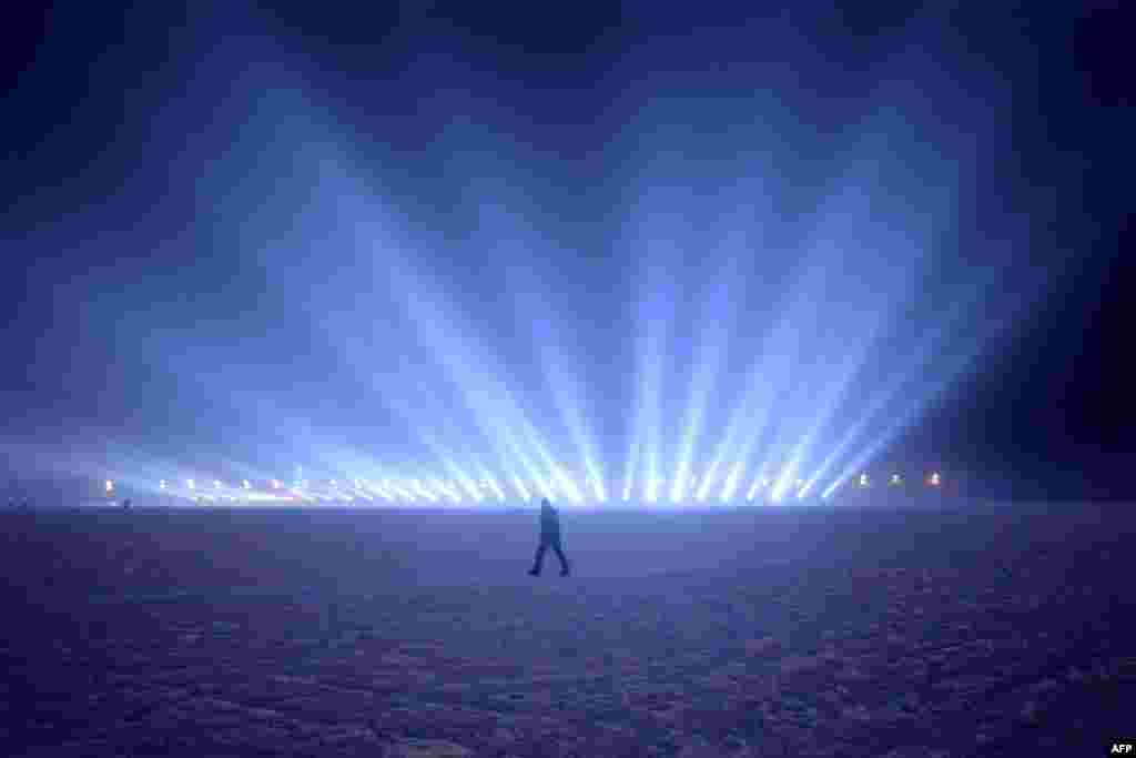 A man walks on the frozen Songhua river beside the Harbin International Ice and Snow Festival in Harbin, northeast China&#39;s Heilongjiang province.