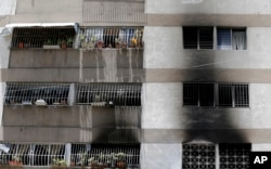 Signs of smoke cover the apartment complex where an allegedly armed drone crashed, causing a fire, in Caracas, Venezuela, Sunday, Aug. 5, 2018.
