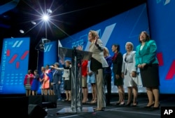 FILE - House Minority Leader Nancy Pelosi of Calif, center, is joined on stage with other woman members of Congress, as she addresses the White House Summit on the United State of Women in Washinton, June 14, 2016.