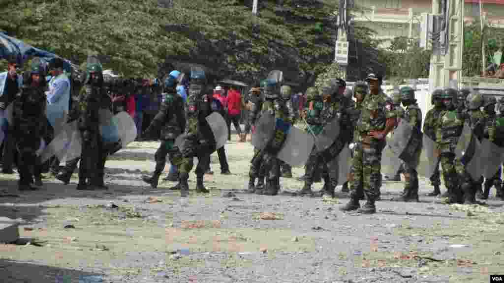 Police with riot gear gather near striking garment workers in Phnom Penh, Jan. 2, 2014. (VOA Khmer)