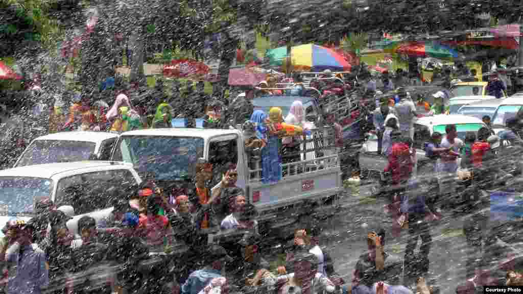 Reaksi orang-orang di sebuah truk setelah disemprot air sementara yang lainnya membalas dengan pistol air dalam festival air tradisional Myanmar di Pyi Road di Rangoon, Myanmar, 16 April 2014. (MoeMoe Htun/VOA).