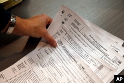 지난 1월 미국 콜로라도주 볼더시의 한 회계 사무실에서 회계사가 세금 보고 관련 서류를 들고 있다. (자료사진)