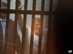 FILE - Egypt's ousted Islamist President Mohammed Morsi sits in a soundproof glass cage inside a temporary courtroom at Egypt’s national police academy in Cairo, Egypt, Tuesday, April 21, 2015.