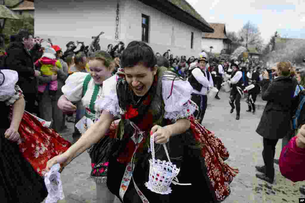 Young women dressed in folk costumes run away from young boys, who try to pour water on them in Holloko, a mountain village enlisted on the World Heritage List of Unesco, some 80 kms northeast of Budapest, Hungary, on Easter.