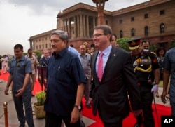 FILE - U.S. Defense Secretary Ashton Carter, right, walks with Indian Defense Minister Manohar Parrikar after receiving a ceremonial welcome in New Delhi, June 3, 2015.