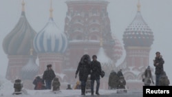 FILE - People walk in Red Square during heavy snowfall in Moscow, Russia, Jan 27, 2019.