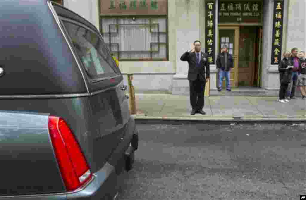 A man salutes as Pvt. Danny Chen's funeral procession passes on Thursday, Oct. 13, 2011 in New York. Chen was killed on Oct. 3 in a noncombat-related death in Kandahar province in Afghanistan. (AP Photo/Jin Lee)