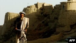 An Afghan man rides his bicycle through an old city area of Ghazni province, August 20, 2007. (Click to Expand)