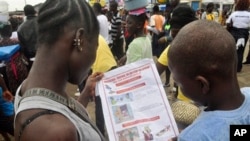Liberian children read a leaflet with guidelines to protect the community from the Ebola virus, in Monrovia, Liberia. Monday, Oct. 13, 2014. Some nurses in Liberia defied calls for a strike on Monday and turned up for work at hospitals amid the worst Ebola outbreak in history. In view of the danger of their work, members of the National Health Workers Association are demanding higher monthly hazard pay. The association has more than 10,000 members, though the health ministry says only about 1,000 of those are employed at sites receiving Ebola patients. (AP Photo/Abbas Dulleh)