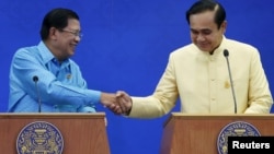 Cambodia's Prime Minister Hun Sen (L) and Thailand's Prime Minister Prayuth Chan-ocha shake hands during a news conference after an agreement signing ceremony at the Government House in Bangkok, Thailand, Dec.19, 2015.