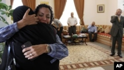 Dr. Fatima Haji, second left, hugs an unidentified woman after getting word of a judge's verdict Thursday, June 14, 2012, at a fellow doctor's home in Sehla, Bahrain.