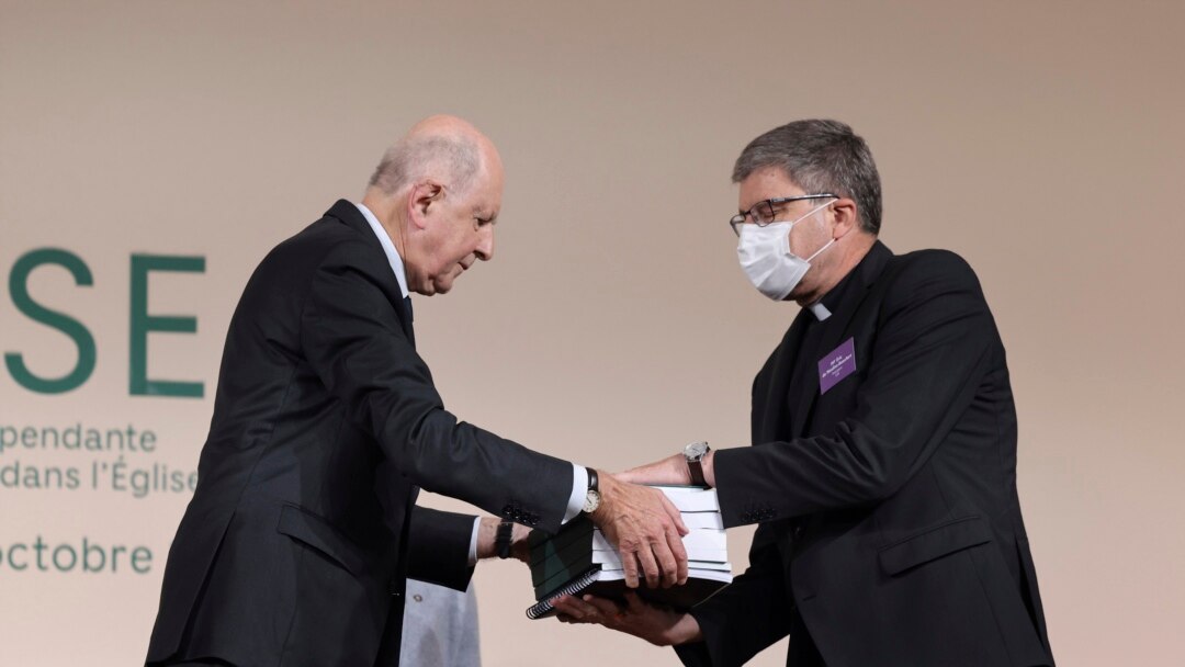 FILE - Commission president Jean-Marc Sauve, left, hands copies of the report to Catholic Bishop Eric de Moulins-Beaufort, president of the Bishops' Conference of France.
