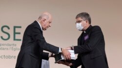 FILE - Commission president Jean-Marc Sauve, left, hands copies of the report to Catholic Bishop Eric de Moulins-Beaufort, president of the Bishops' Conference of France.