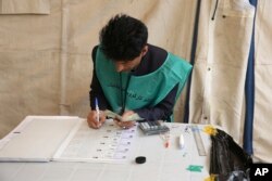 An Afghan employee of the Independent Election Commission registers a resident at a voter registration center for the upcoming parliamentary and district council elections in Kabul, Afghanistan, April 18, 2018.