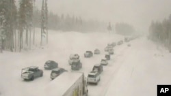 지난 23일 미국 80번 주간 고속도로 캘리포니아 구간이 눈에 덮인 가운데, 차량들이 멈춰 서 있다. 