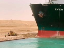 In this photo released by the Suez Canal Authority, a cargo ship, named the Ever Given, sits with its bow stuck into the wall Wednesday, March 24, 2021, after it become wedged across Egypt’s Suez Canal and blocked all traffic in the vital waterway. (Suez