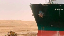 In this photo released by the Suez Canal Authority, a cargo ship, named the Ever Given, sits with its bow stuck into the wall Wednesday, March 24, 2021, after it become wedged across Egypt’s Suez Canal and blocked all traffic in the vital waterway.