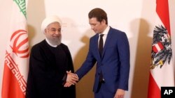 Austrian Chancellor Sebastian Kurz, right, welcomes Iranian President Hassan Rouhani, left, for a meeting at the federal chancellery in Vienna, Austria, Wednesday, July 4, 2018.