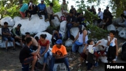 Migrantes de la caravana que trata de llegar hasta Estados Unidos esperan una oportunidad para cruzar a México desde Tecun Uman, Guatemala, el 21 de enero de 2020.