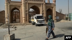 塔利班战斗人员走过发生爆炸的喀布尔埃德加清真寺的入口。（2021年10月4日）