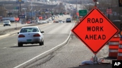 FILE - Construction signs warn drivers on US Route 550 as crews prepare to begin work on the highway in Bernalillo, N.M., Feb. 19, 2015. President Donald Trump has repeatedly pledged, including in his speech Tuesday to Congress, to seek $1 trillion in public and private funds to improve America's infrastructure and create jobs.