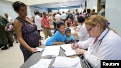 Archivo - Una doctora asiste a gente que busca tratamiento para la malaria en un centro de salud en San Felix, Venezuela, el 3 de noviembre de 2017.