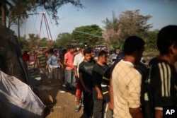 Men line up to receive a donated breakfast, at a sports center where Central American migrants traveling with a U.S. border-bound caravan have been camped out, in Matias Romero, Oaxaca State, Mexico, April 4, 2018.