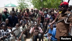 Un groupe de chasseurs traditionnels vigile contre les attaques de Boko Haram dans le camp de Maiduguri, le 21 mai2014.