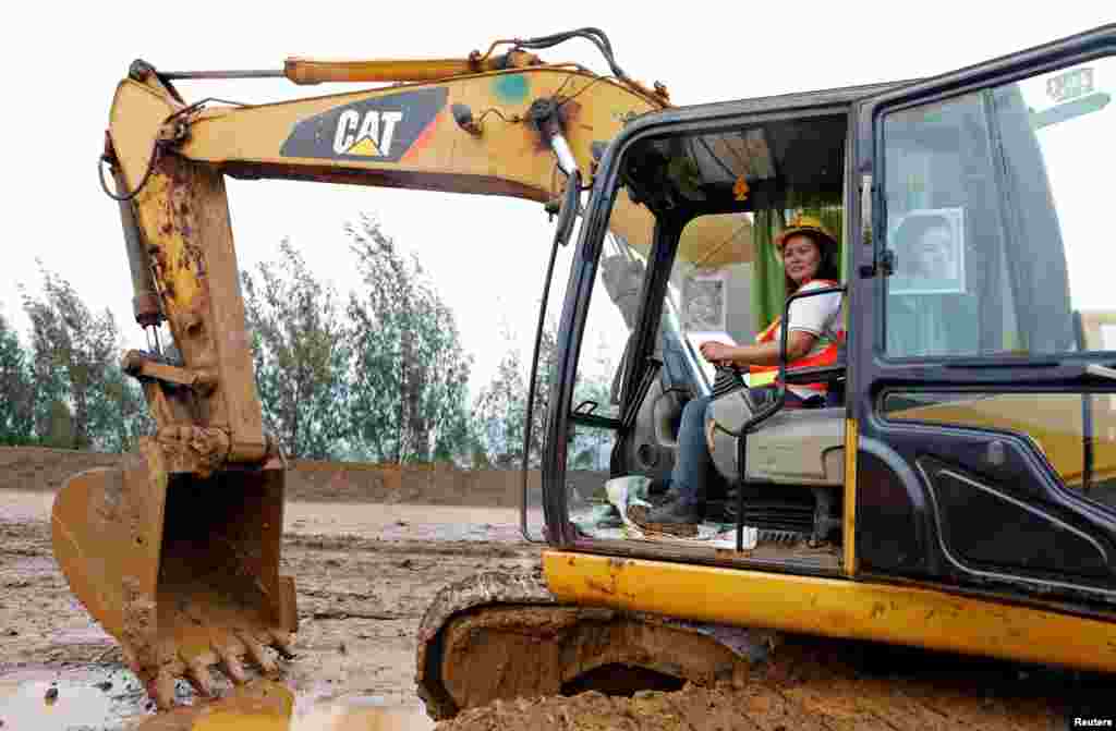 Grace Ocol, 40, operator mesin backhoe, berfoto di Tubay, Agusan del Sur, Filipina (16/2). Ibu tiga anak itu mengatakan, &quot;Ada beberapa pekerja perempuan yang mengemudikan truk besar dan backhoe. Kalau laki-laki bisa, kenapa perempuan tidak? Saya lebih baik dari para laki-laki itu, mereka hanya bisa mengemudikan truk di sini, tapi saya bisa kedunya.&quot;&nbsp;(Reuters/Erik De Castro)