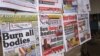 A close-up of newspaper front pages focusing on the Ebola outbreak, including a newspaper, reading 'Burn all bodies' in Monrovia, Liberia, July 31, 2014. 