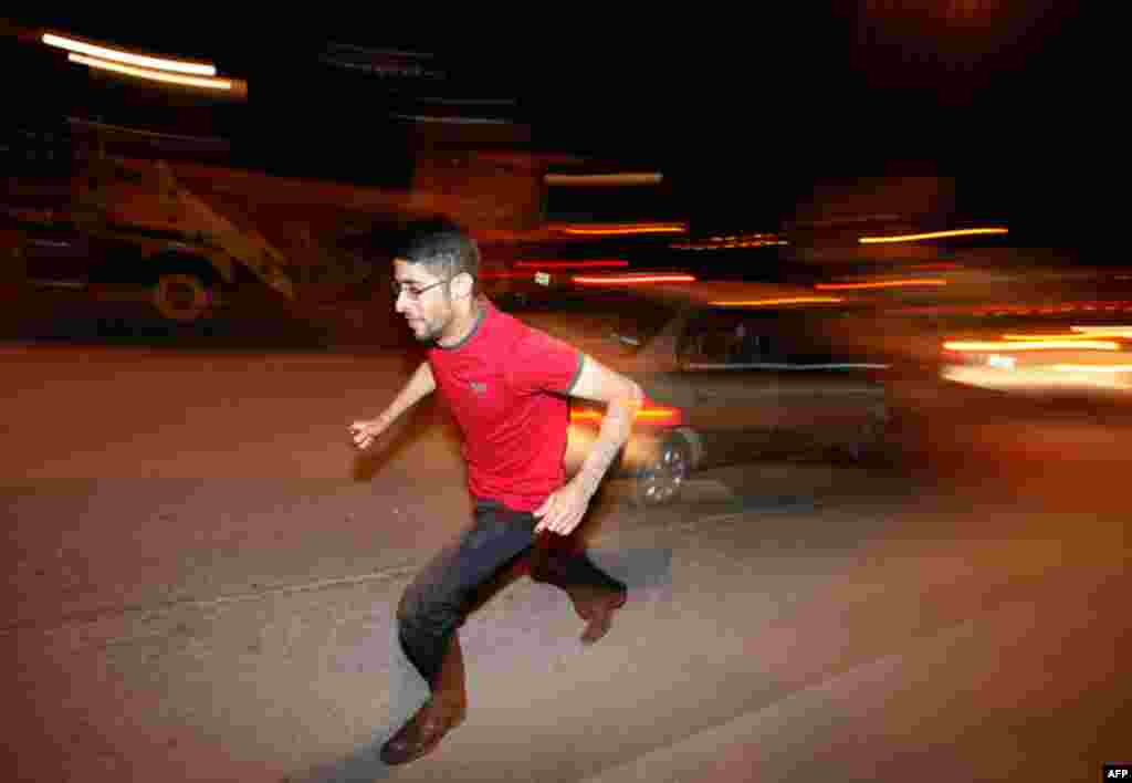 A protester runs for shelter after Bahraini security forces opened fire at protesters marching towards the Pearl Square in capital Manama. (Reuters/Hamad I Mohammed)