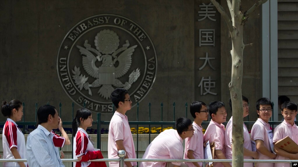 Estudiantes chinos esperan frente a la embajada de EE.UU. en Beijing para entrevistas para obtenciÃ³n de visas.