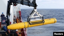 Crew aboard the Australian Defence Vessel Ocean Shield move the U.S. Navy's Bluefin-21 autonomous underwater vehicle into position for deployment in the southern Indian Ocean to look for the missing Malaysia Airlines flight MH370, April 14, 2014.